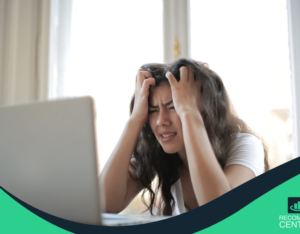 Mujer molesta con las manos en la cabeza representando: cómo salir de deudas