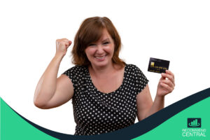 Mujer riendo y sosteniendo tarjeta de crédito